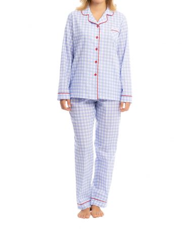 Woman with Women's long pyjamas in plumeti check pattern with red piping trim.