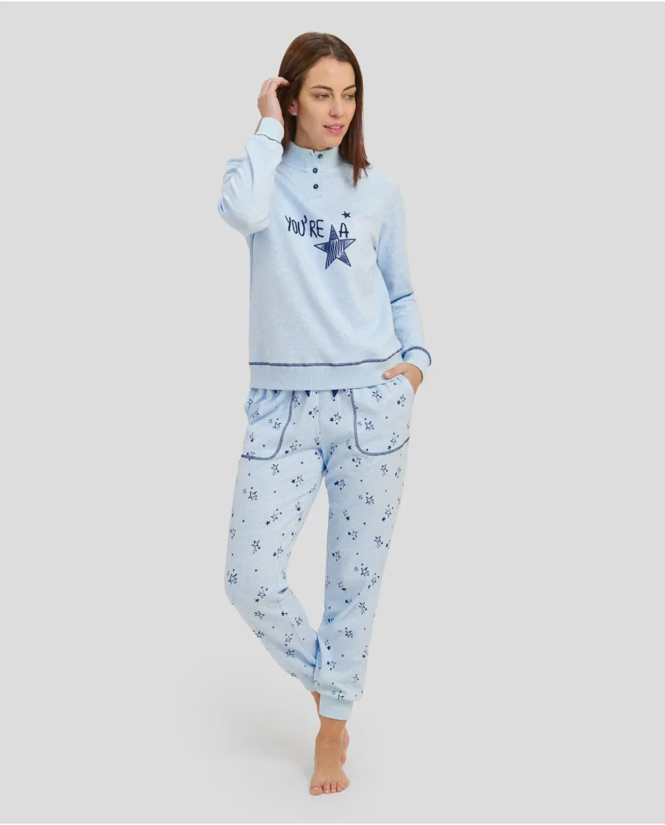 Woman with closed long light blue pyjamas with embroidery on jacket and trousers of little stars