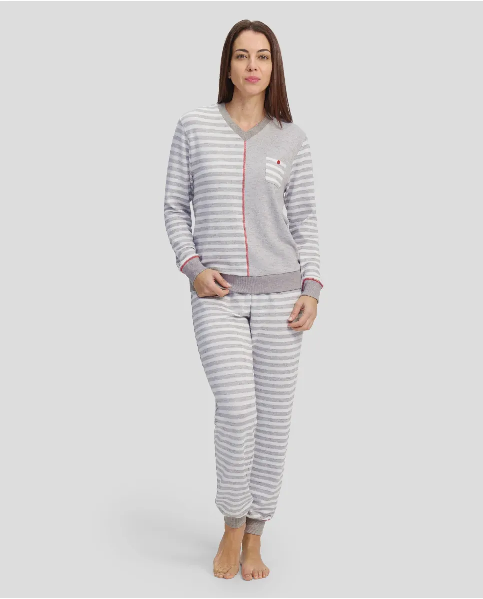 Woman in closed winter pyjamas with grey striped cuffs and red detailing