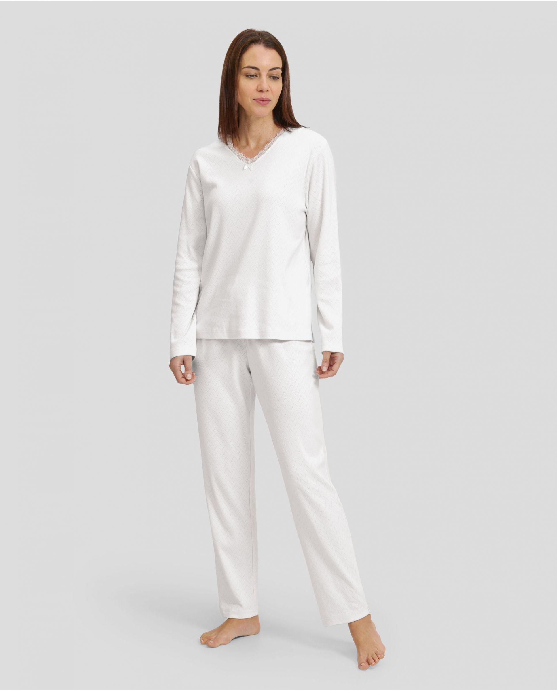 Woman in ivory winter lingerie pyjamas with V-neck and lace