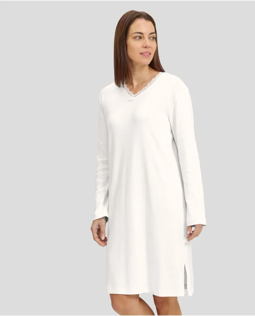 Woman in ivory long-sleeved winter lingerie nightdress with V-neck and lace collar