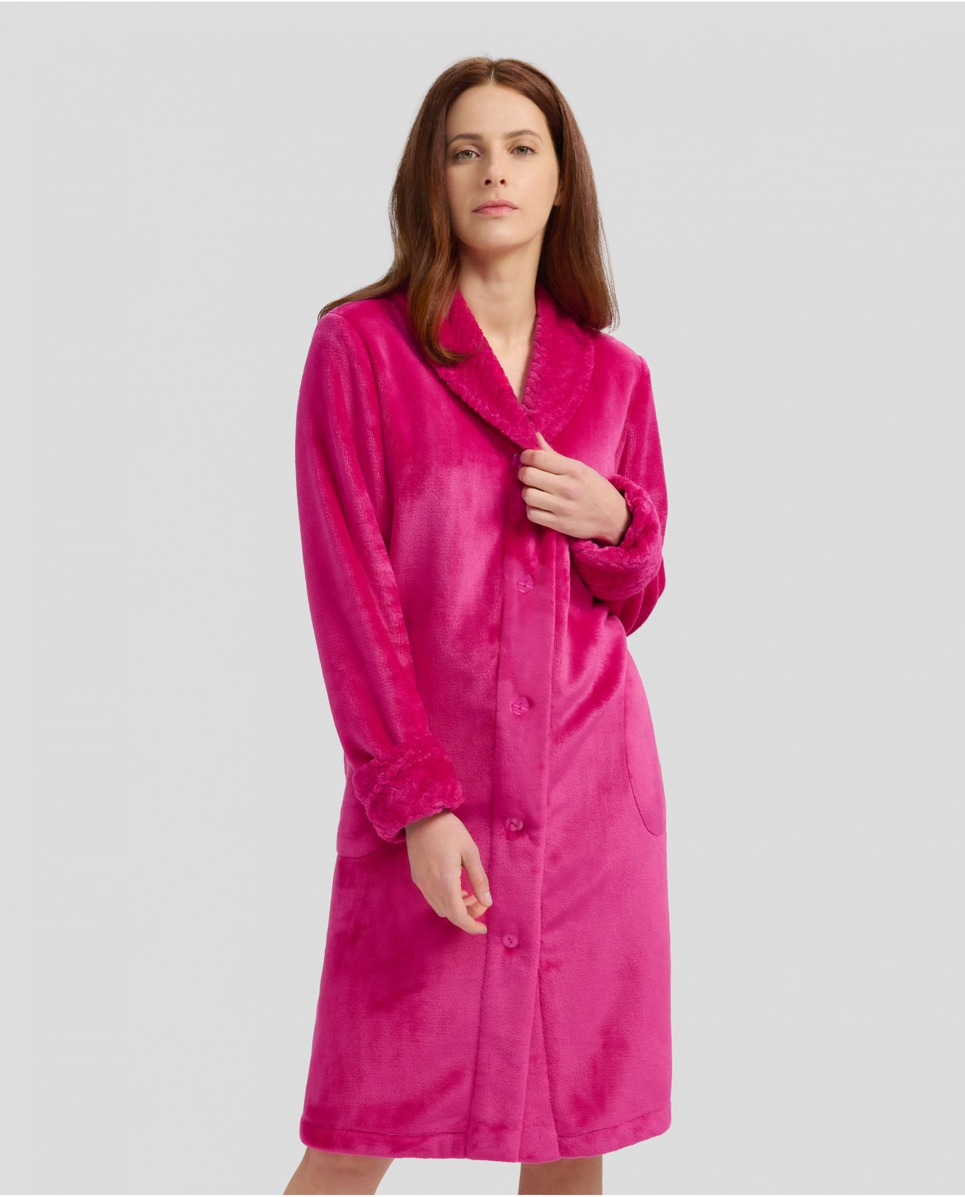 Woman in fuchsia flannel long dressing gown, buttoned and with pockets for winter