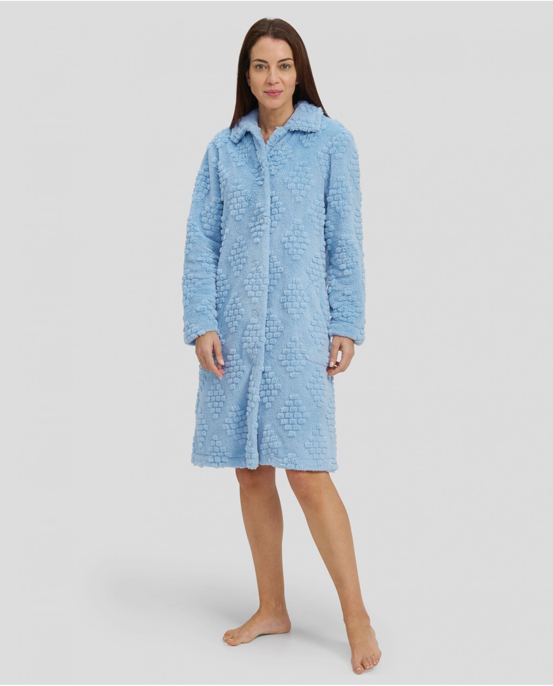 Woman in light blue jacquard long winter coat, buttoned and with pockets