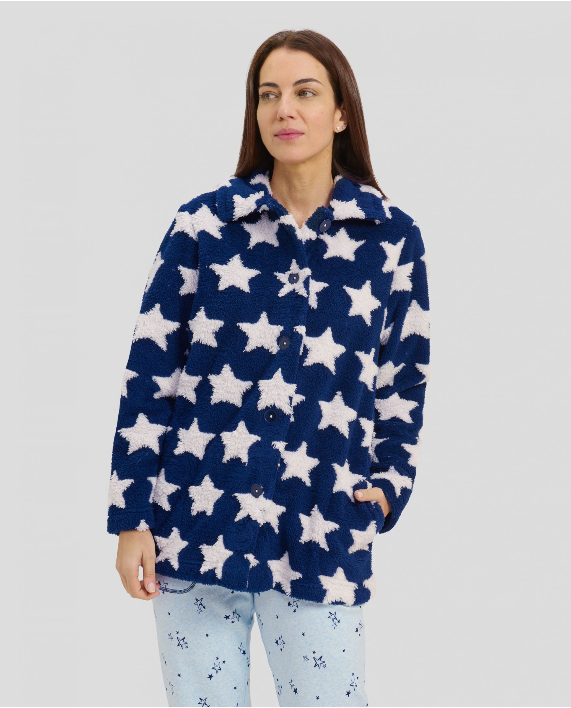 Woman in short navy buttoned dressing gown with white stars and pockets