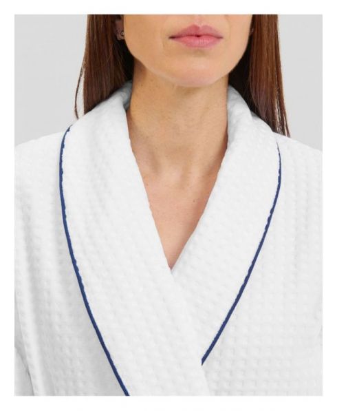 Detail view of the dinner jacket collar of white women's bathrobe with contrasting blue piping