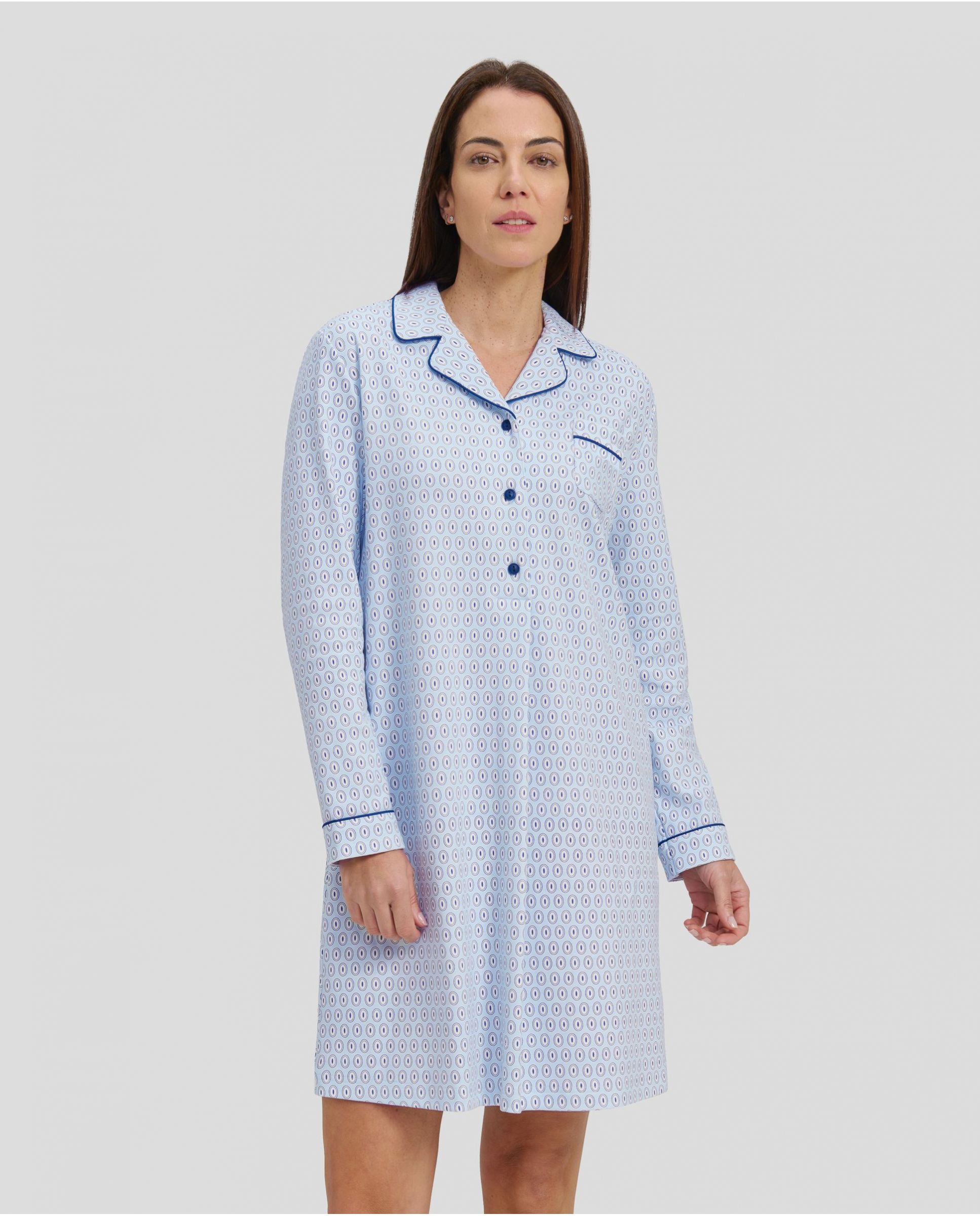 Woman in light blue oval winter long nightdress with open collar with blue buttons and piping