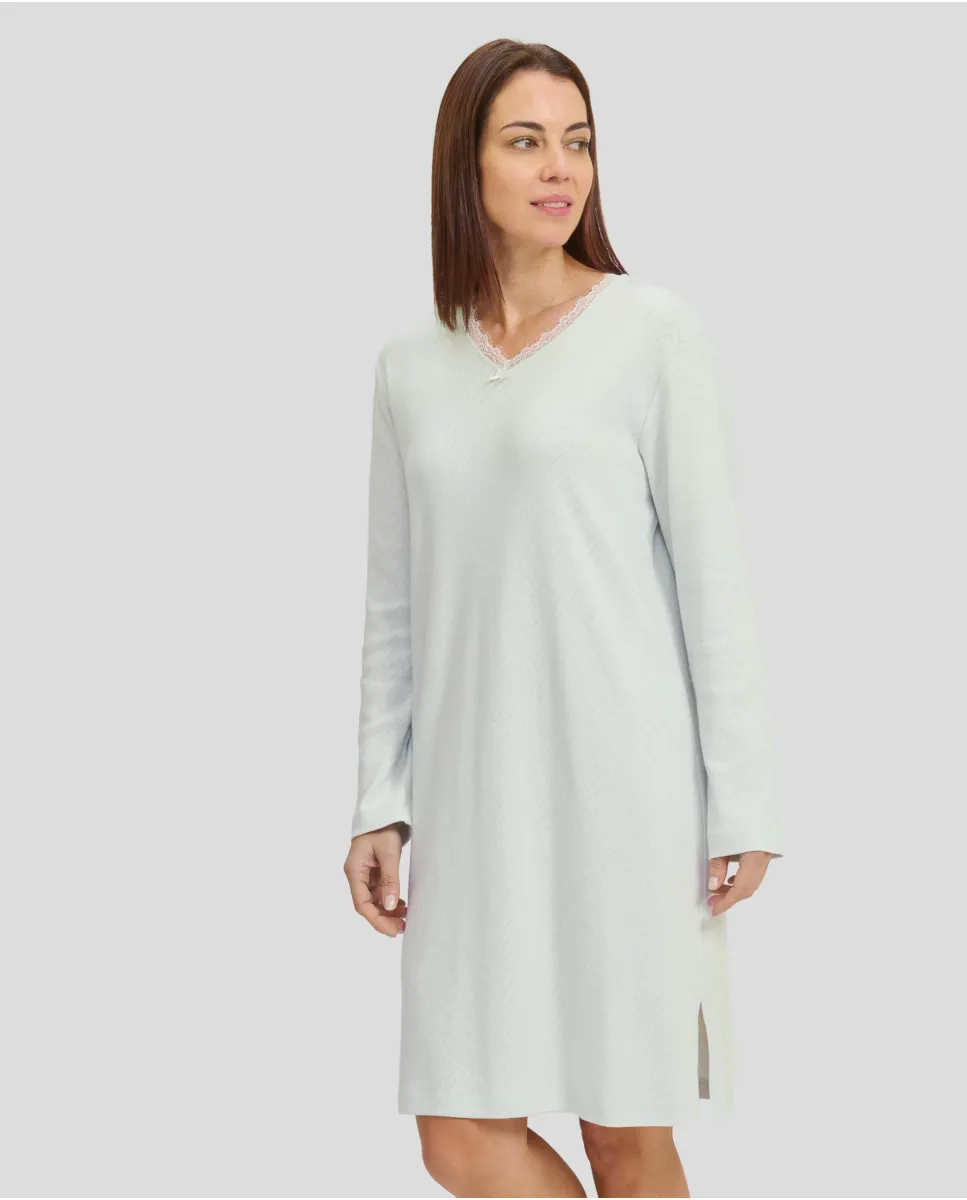 Woman in ivory long-sleeved winter lingerie nightdress with V-neck and lace collar