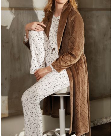 Seated woman in long-sleeved floral pyjamas with round neck and button fastenings