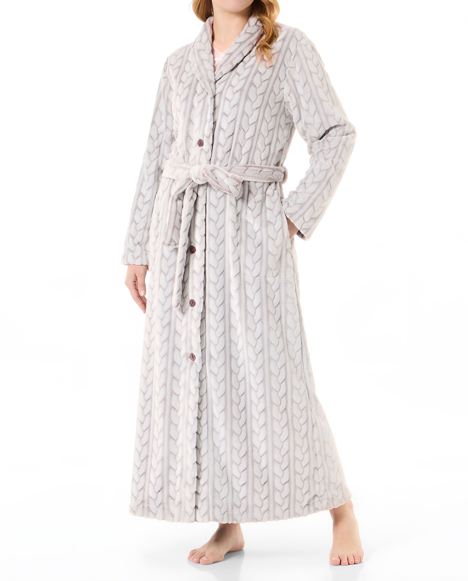 Woman in long brown braid woven dressing gown, open with buttons, belt and side pockets.