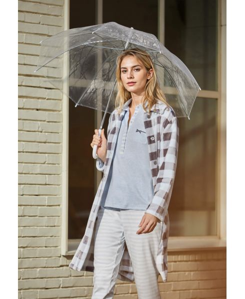 Woman walks down the street in her pyjamas wearing a light blue check patterned long gown