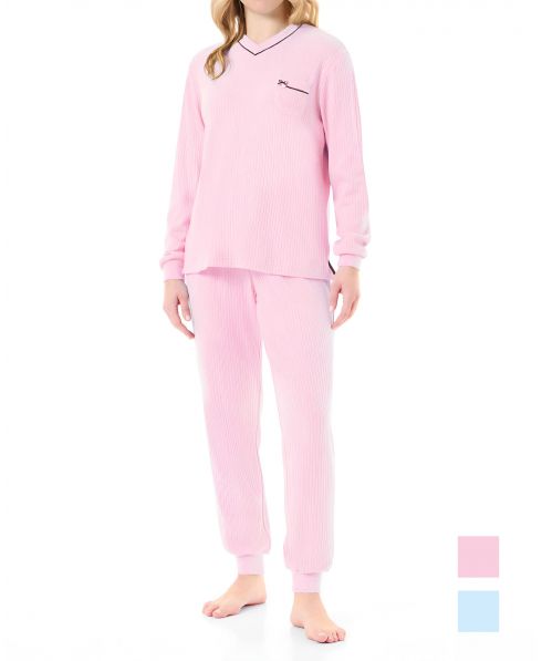 Woman in pink ribbed long pyjamas with long-sleeved jacket and plain cuffs and trousers