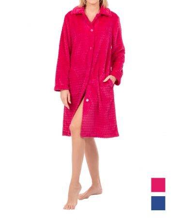 Una mujer en una bata larga y cómoda de invierno, devorado color fucsia con botones  ante fondo blanco.