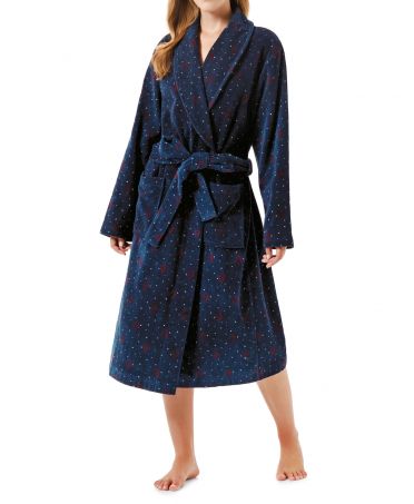 Woman in long terry towelling bathrobe with pockets and christmas motifs