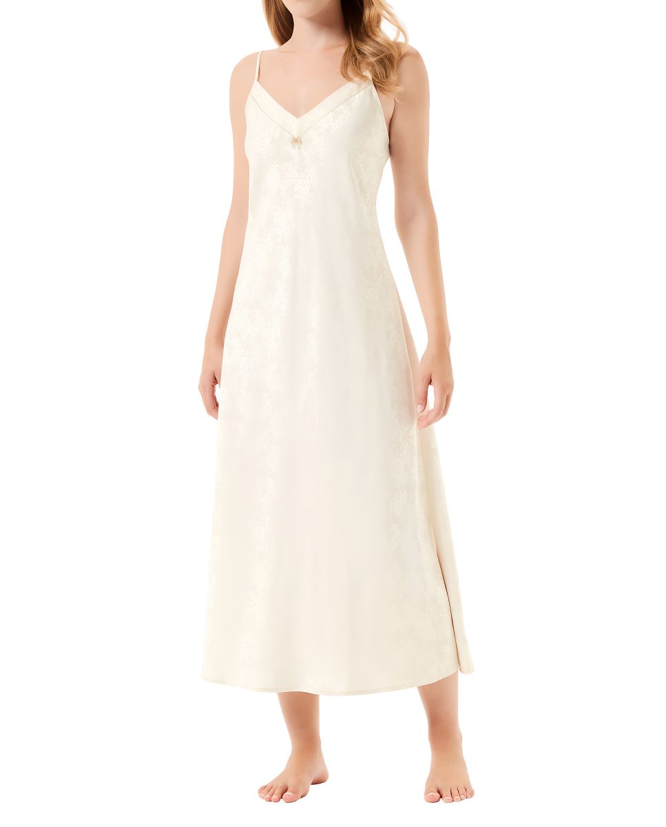 Woman wearing a sensual long strapless nightdress in champagne-coloured jacquard with a V-neckline.