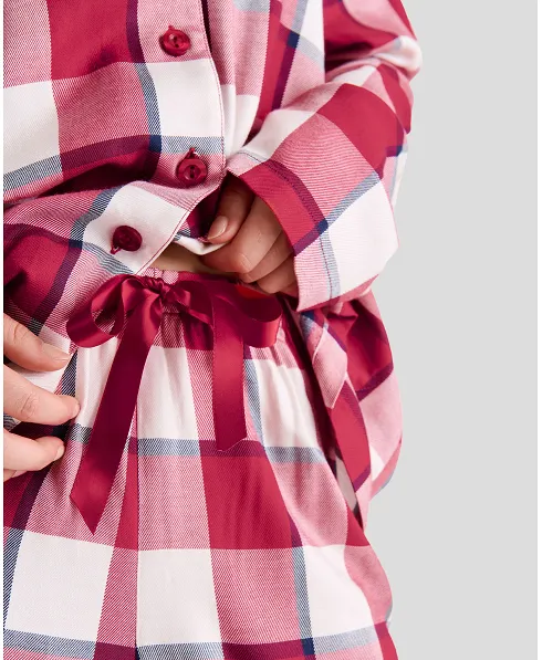 Detail view of open checked pyjama jacket with buttons and trousers with bow