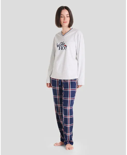 Woman in long Christmas pyjamas with plain embroidered V-neck top and matching navy checked trousers.