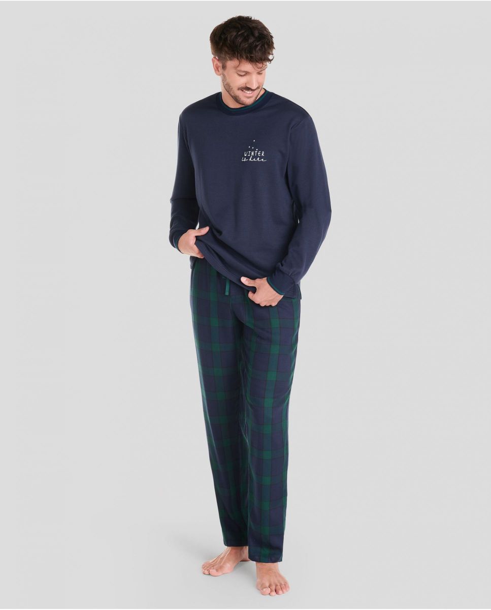 Man in navy Christmas long pyjamas and green checked trousers