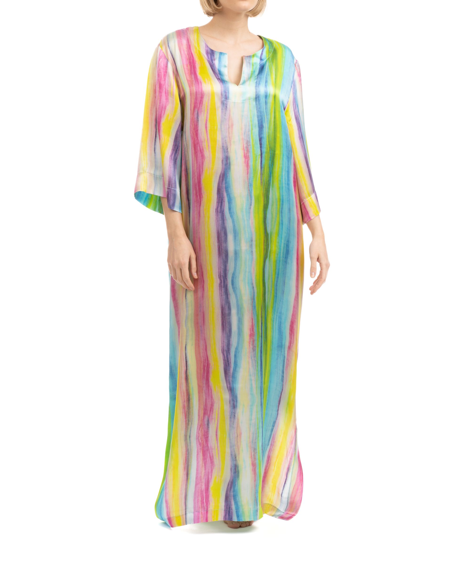 Mujer posa con kaftan de seda largo con aberturas laterales y escote redondo, trazos multicolor