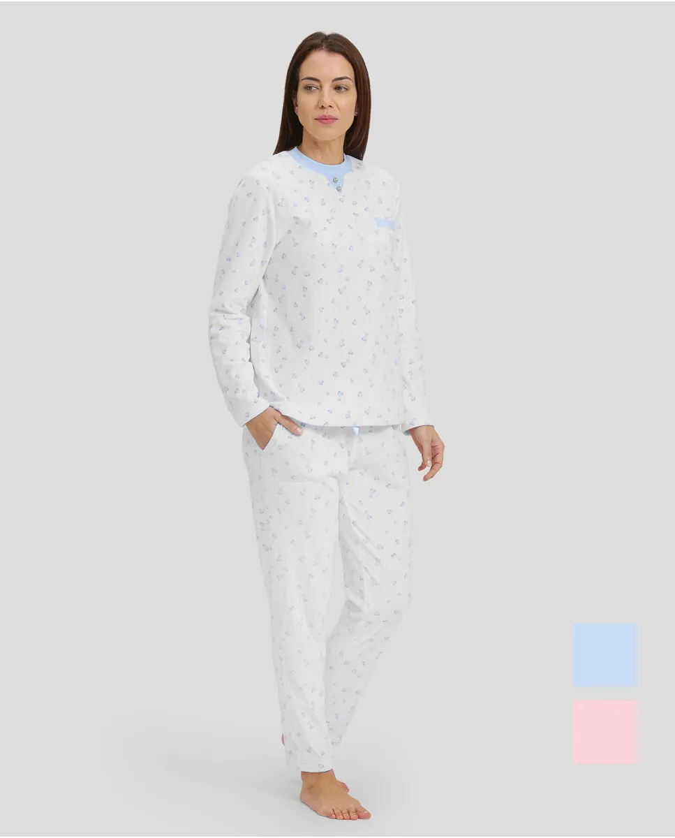 Woman in ivory winter pyjamas with light blue hearts and detailing on collar, pocket and cuffs