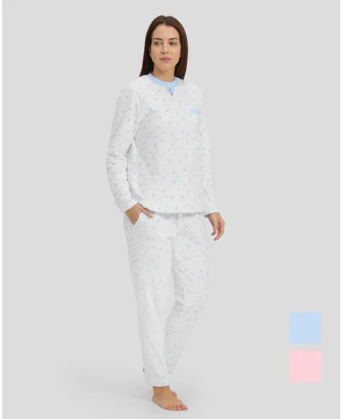 Woman in ivory winter pyjamas with light blue hearts and detailing on collar, pocket and cuffs