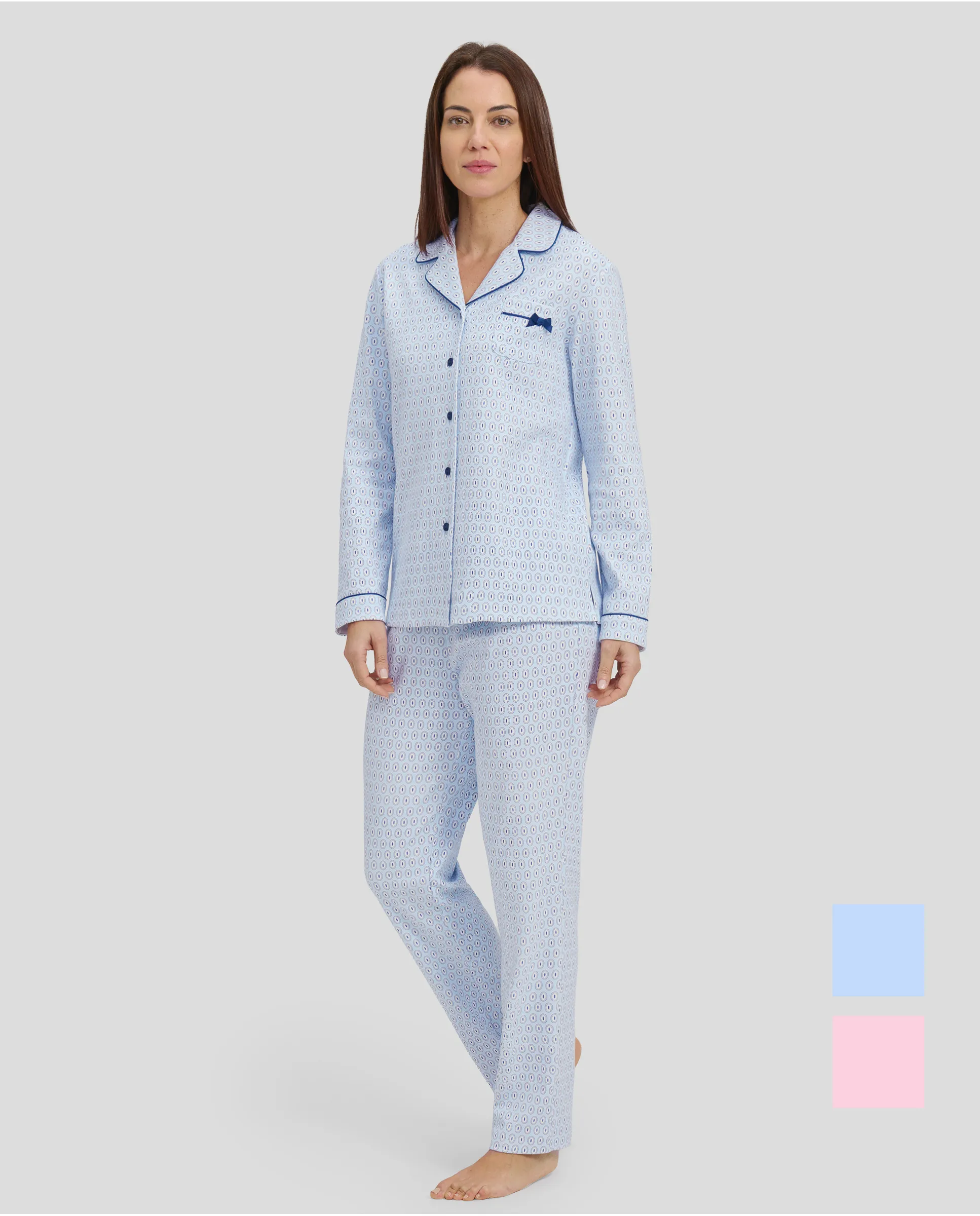 Woman in light blue shirt pyjamas with buttoned ovals and contrasting piped collar.