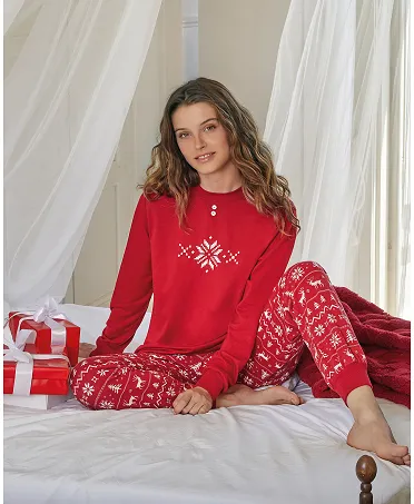 Mujer con acogedor y elegante pijama navideño rojo con dibujos de copos de nieve y renos