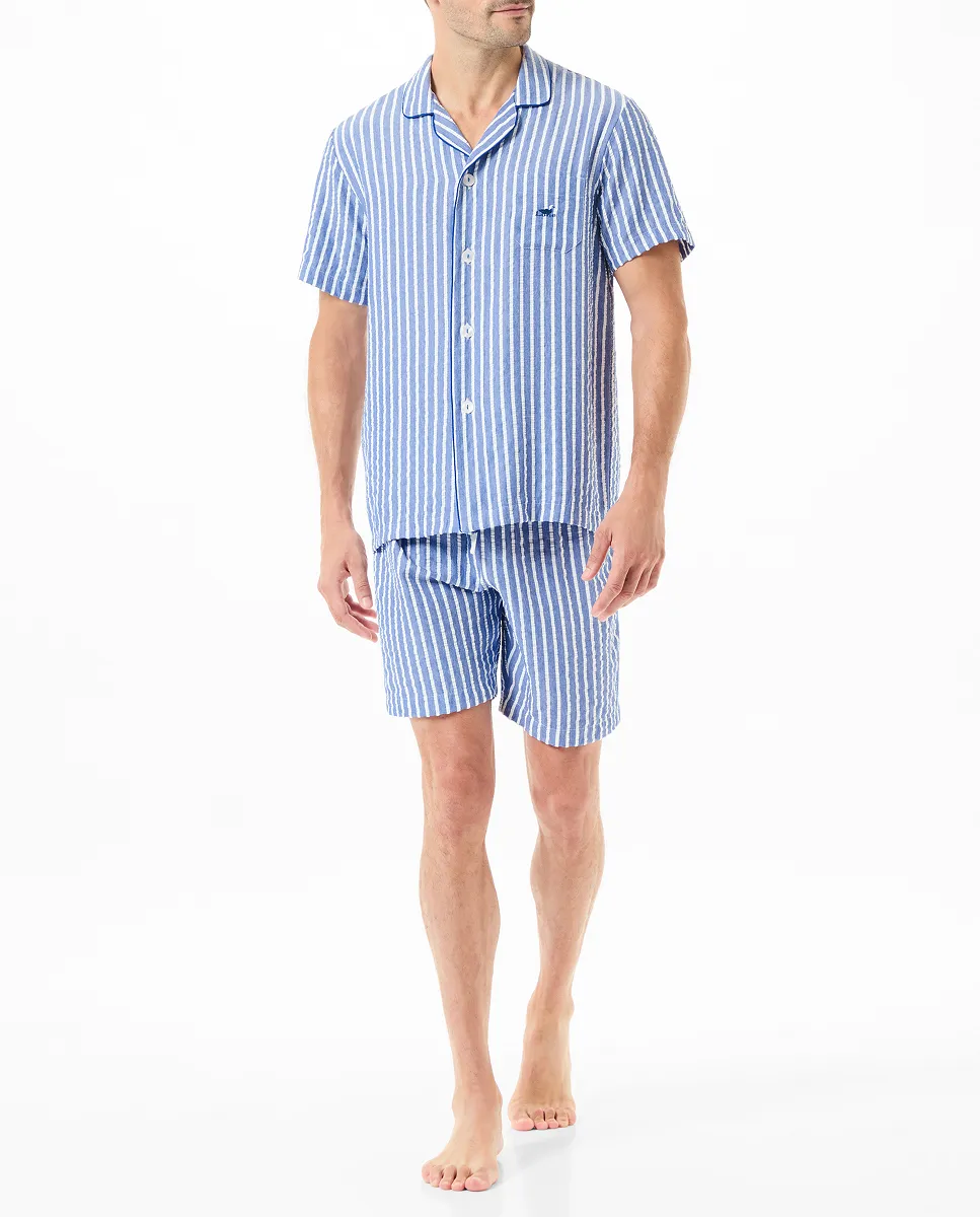 A man wearing a blue and white striped open short pyjama set.