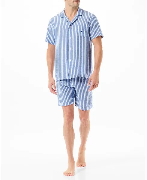 A man wearing a blue and white striped open short pyjama set.