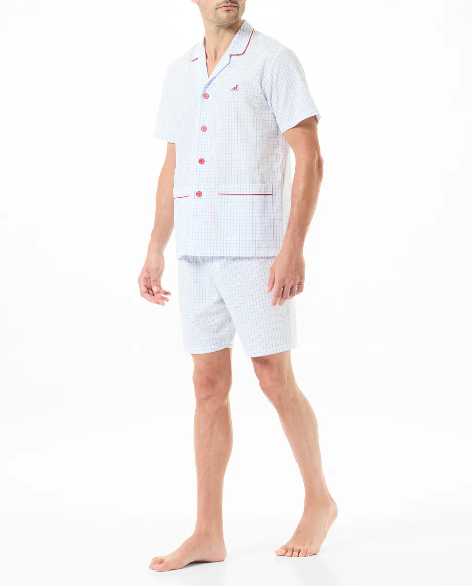 Man poses in summer pyjamas with open jacket with buttons and short sleeves.