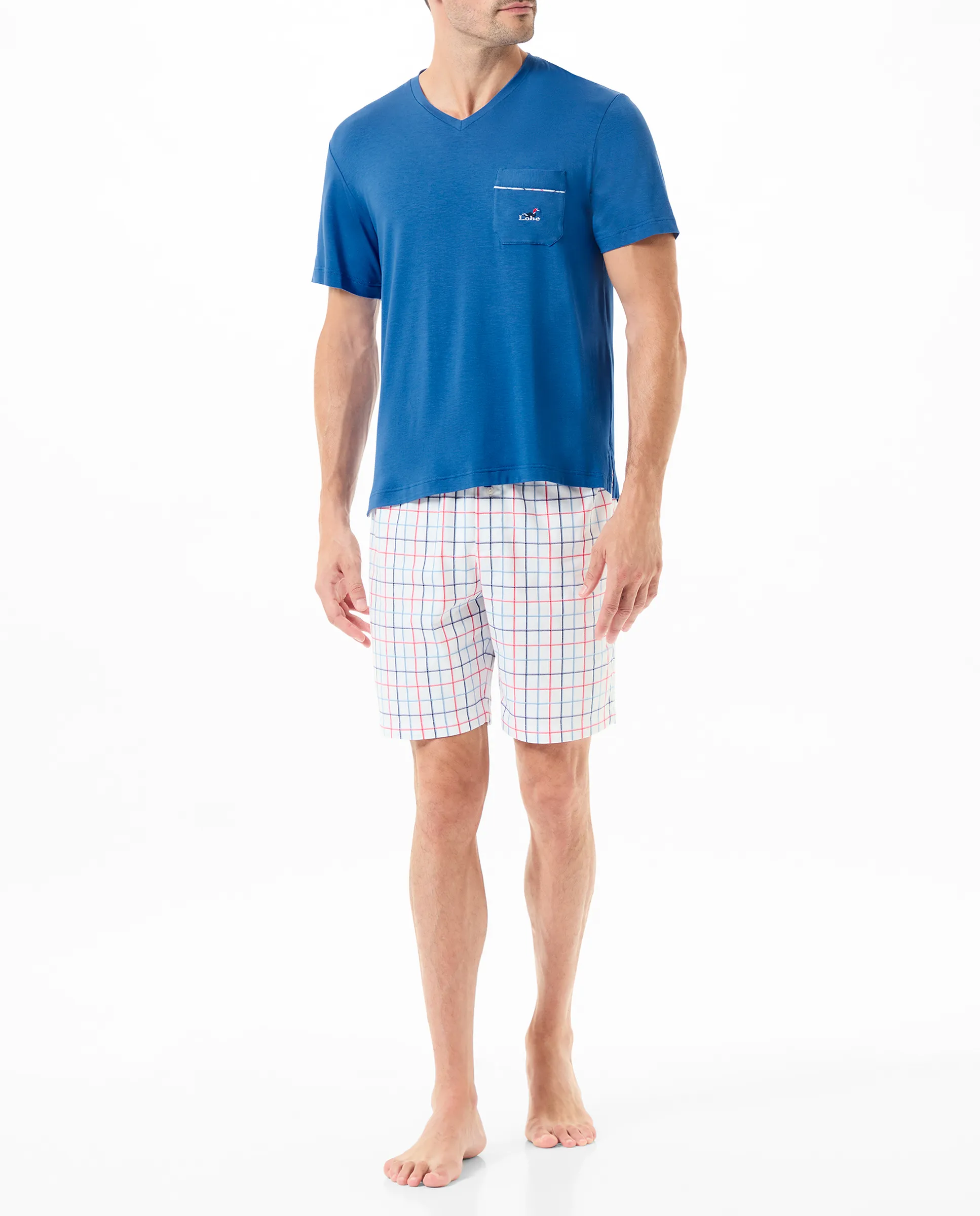 Man wears short summer pyjamas with blue T-shirt and check print trousers.