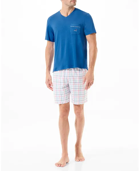 Man wears short summer pyjamas with blue T-shirt and check print trousers.