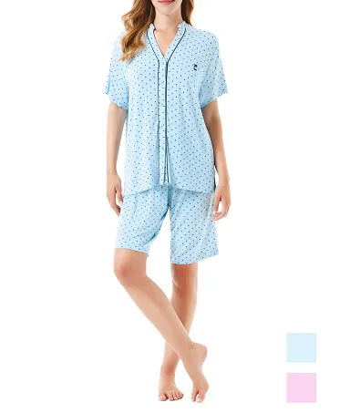 A woman wears a blue short-sleeved pyjama set with little hearts.