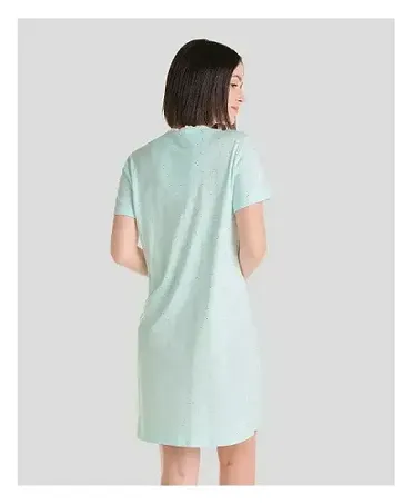 Woman on her back wearing short light green summer nightgown with silver details