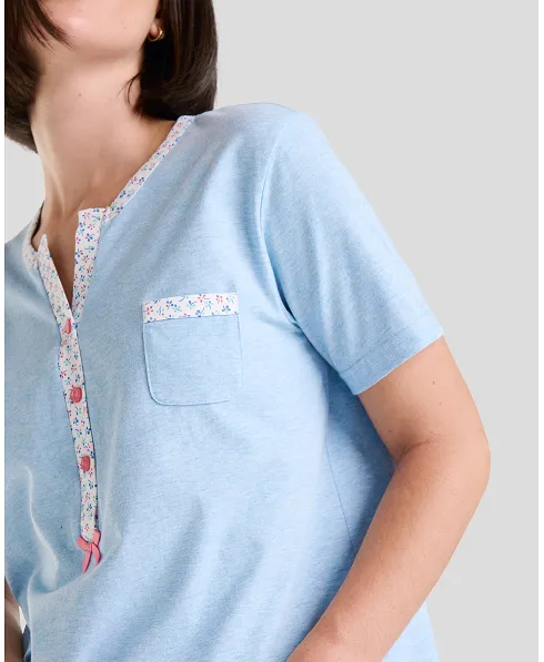 Detail of blue short-sleeved women's summer pyjama top with flower details, open collar with pink buttons and decorative pocket