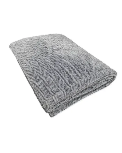 Manta de casa en tejido de espiga amoroso y cálido de color gris sobre el sofá