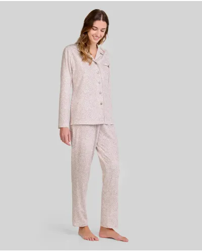 Woman wearing camel-coloured long-sleeved pyjamas with a floral print, ideal for sleeping comfortably.