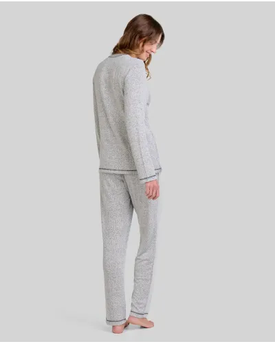 Woman wearing grey long-sleeved winter pyjamas with buttoned collar and pocket