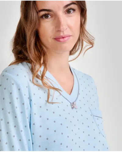 Woman wearing long-sleeved pyjamas for winter in sky blue with grey polka dots and decorative pocket