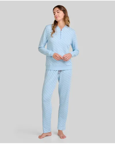Woman wearing warm, long, sky blue pyjamas in a twill fabric with a small grey polka dot print.