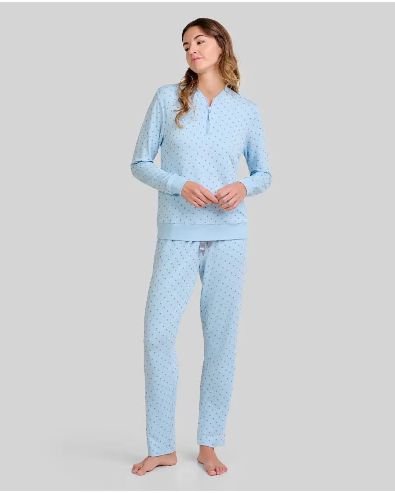 Woman wearing warm, long, sky blue pyjamas in a twill fabric with a small grey polka dot print.