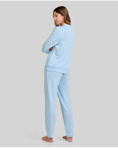 Woman wearing warm, long, sky blue pyjamas in a twill fabric with a small grey polka dot print.