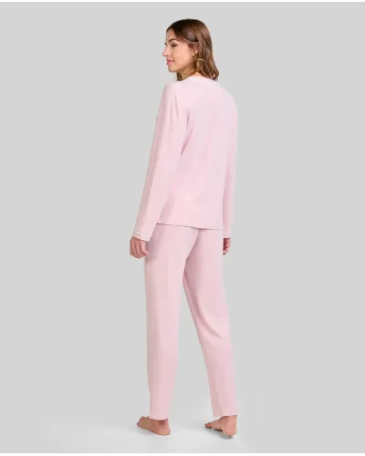 Woman wearing long pink melange winter pyjamas with a V-neck decorated with white trim