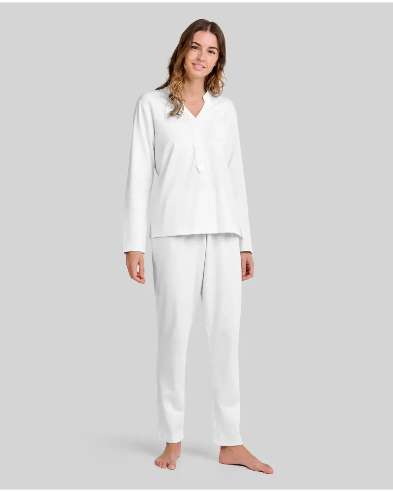 Woman wearing ivory-coloured long nightdress pyjamas with an open neckline, lace trim and bow