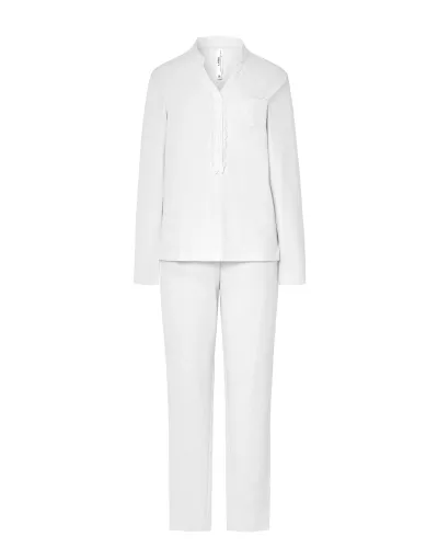 Woman wearing ivory-coloured long nightdress pyjamas with an open neckline, lace trim and bow