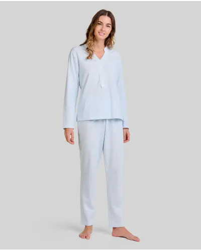 Woman wearing light blue long nightdress pyjamas with an open neckline, lace trim and bow