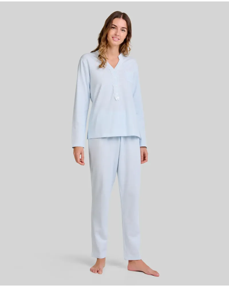 Woman wearing light blue long nightdress pyjamas with an open neckline, lace trim and bow