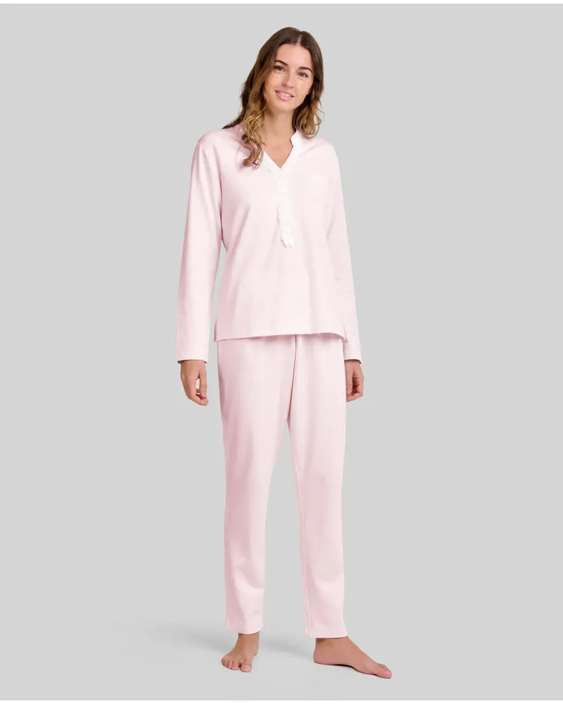 Woman wearing pale pink long nightdress pyjamas with open neckline, lace trim and bow