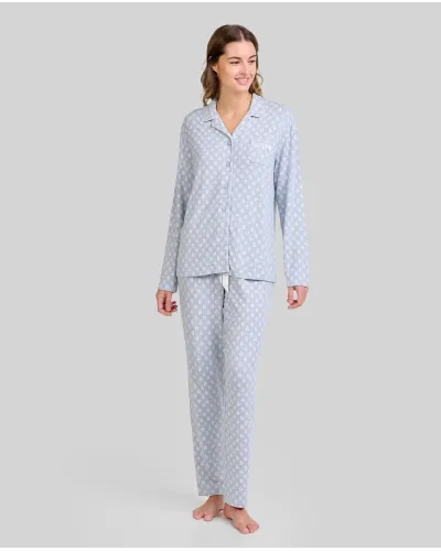 Woman wearing steel blue pyjamas with a white leaf print. Comfortable clothing for sleeping and relaxing.