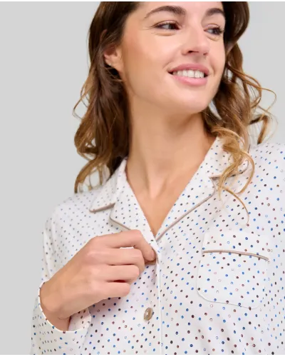 Woman wearing long-sleeved button-down pyjama top with circle print