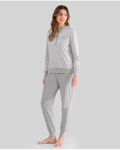 Woman wearing long grey striped pyjamas with a turtleneck top and long grey melange trousers